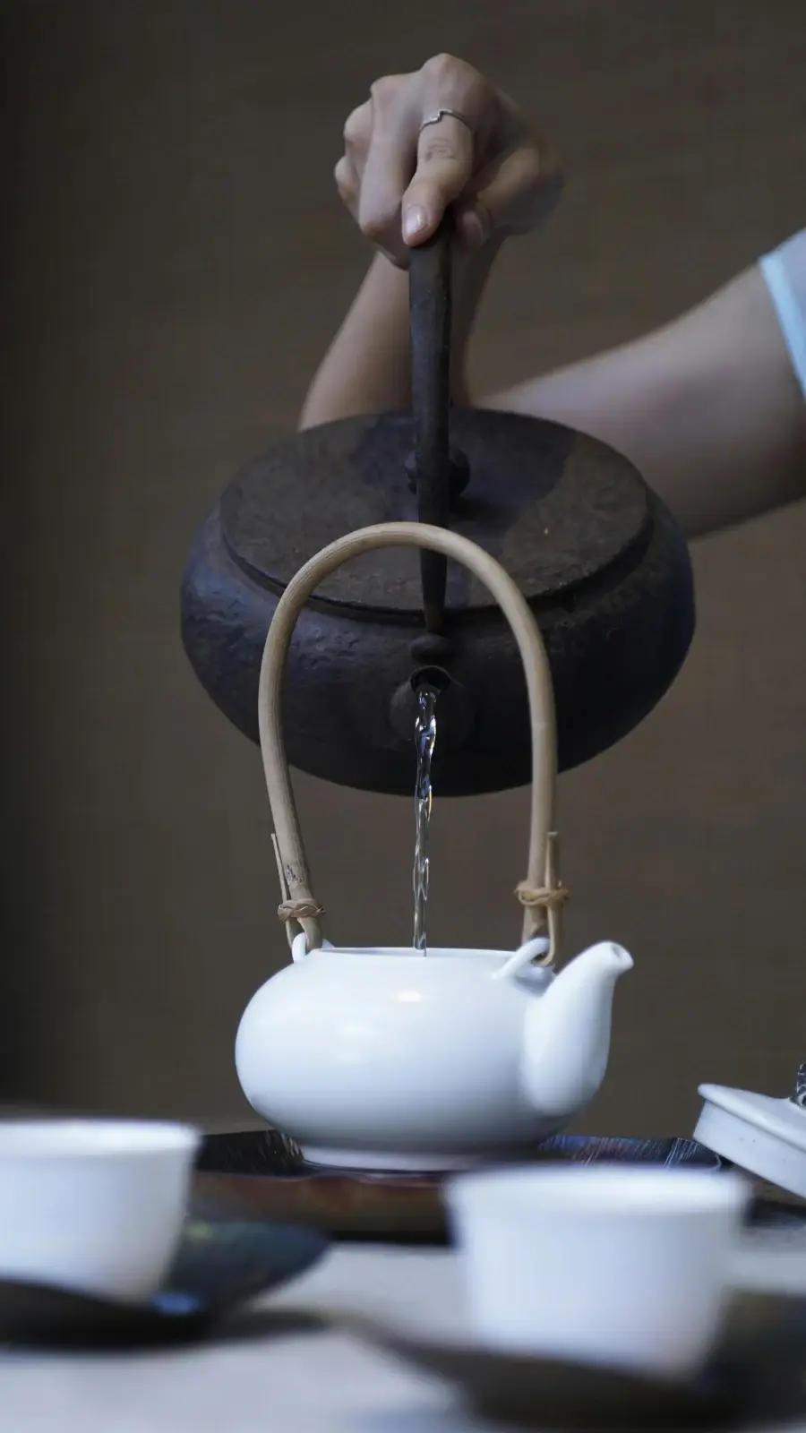 Cast-iron kettle pouring into a teapot