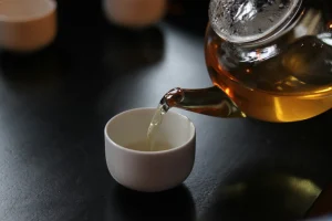 Tea being poured into a cup, dark background